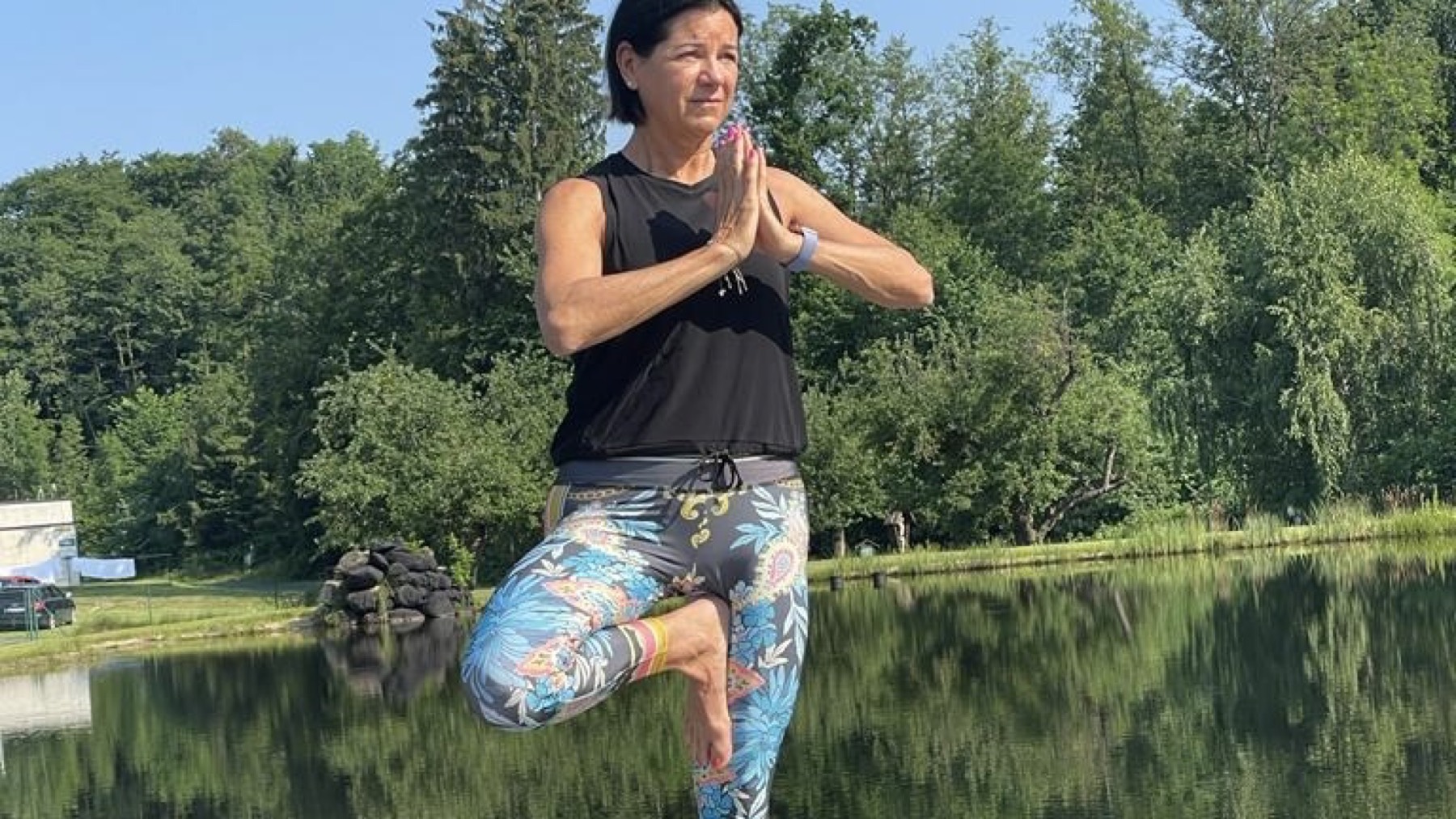 Petra Tutner in einer Yoga-Haltung am See